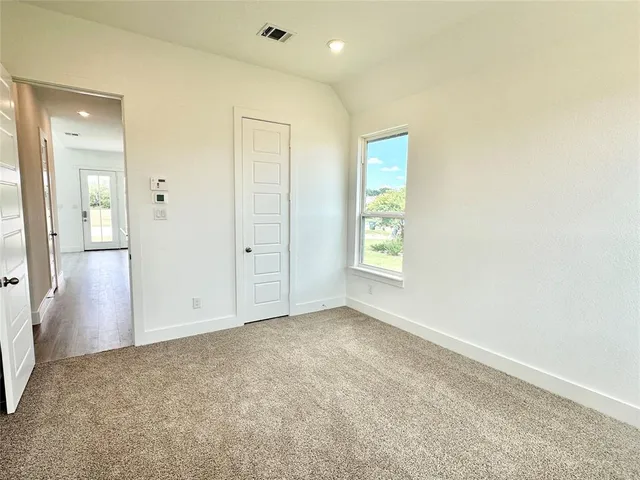 an empty room with windows and closet