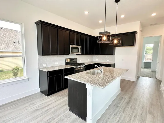 a kitchen with a sink center island cabinets and a window