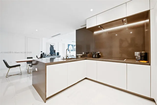 a living room with stainless steel appliances kitchen island granite countertop a sink and cabinets
