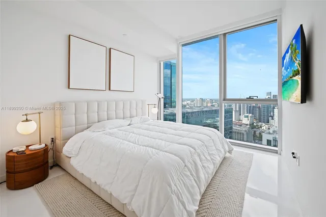 a bedroom with a bed and a large window