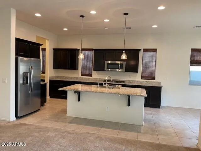 a kitchen with stainless steel appliances granite countertop a sink a stove and a refrigerator