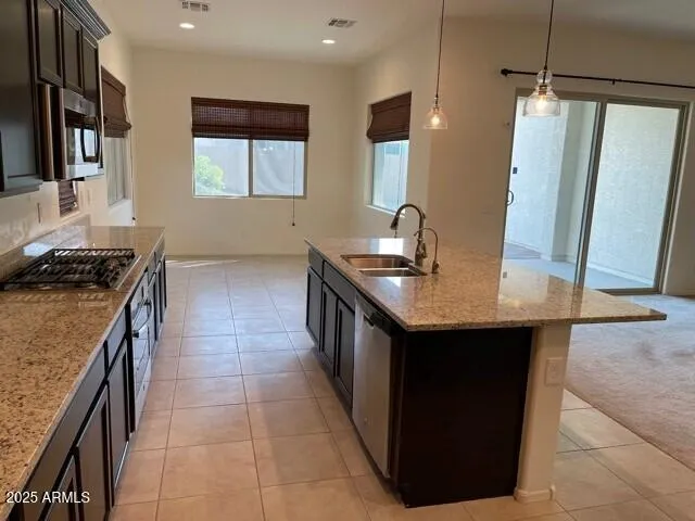 a kitchen with stainless steel appliances granite countertop a sink and a refrigerator