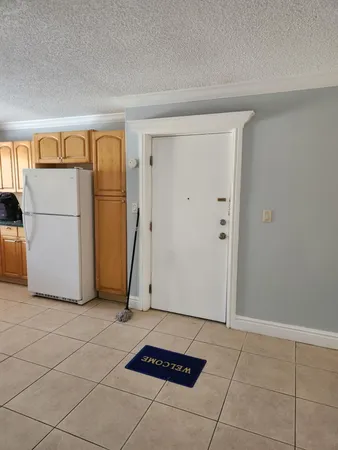 a view of a storage & utility room with fridge and washer dryer