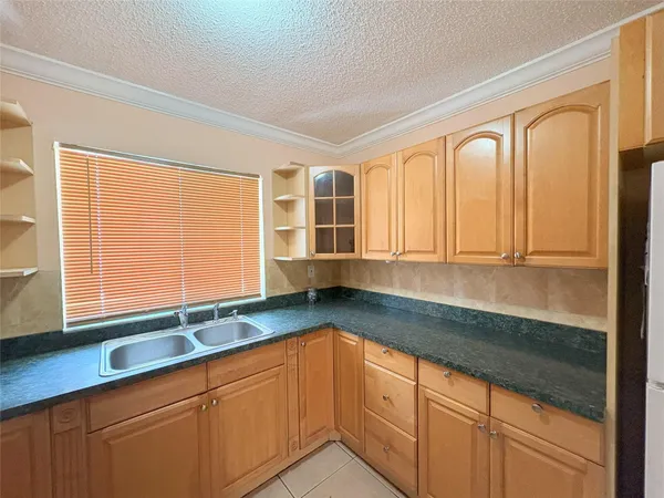 a kitchen with granite countertop cabinets and large window