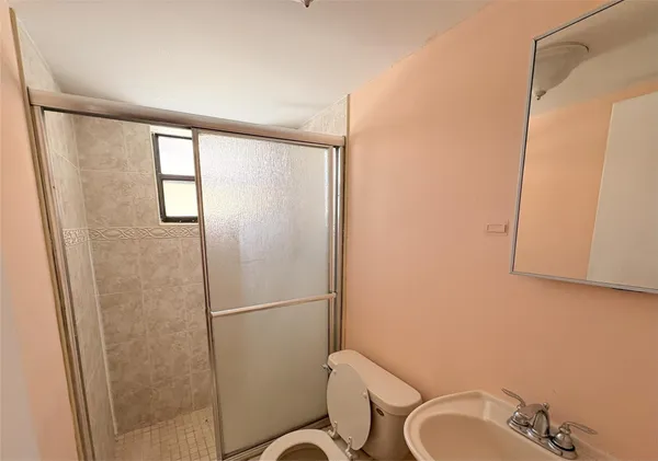 a bathroom with a shower toilet and sink