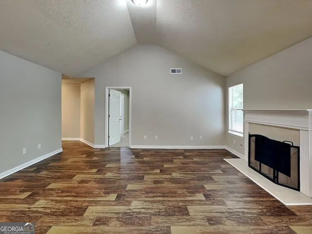 a view of an empty room with a fireplace and a window