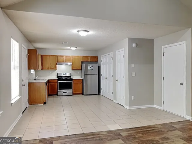 a view of kitchen with kitchen island microwave and cabinets