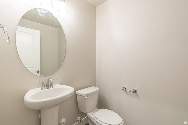 2249 South 1090 West, Unit 76 Nibley, UT 84321 - Photo 7 of 19 Pedestal sink with chrome faucet, oval frameless mirror, and overhead vanity lighting