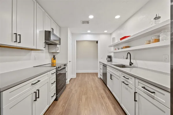 a kitchen with cabinets and stainless steel appliances
