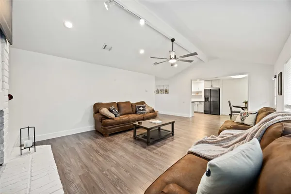 a living room with furniture and a wooden floor
