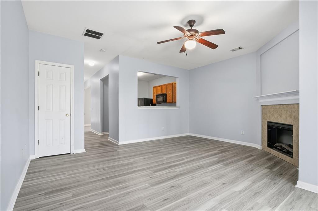 585 McWilliams Road Southeast, Unit 2402 Atlanta, GA 30315 - Photo 11 of 25 a view of an empty room with wooden floor and a fireplace