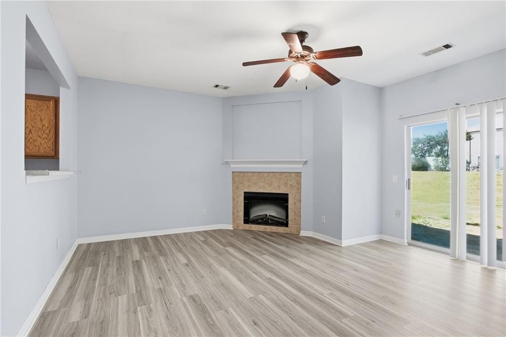 585 McWilliams Road Southeast, Unit 2402 Atlanta, GA 30315 - Photo 12 of 25 a view of empty room with wooden floor and fireplace