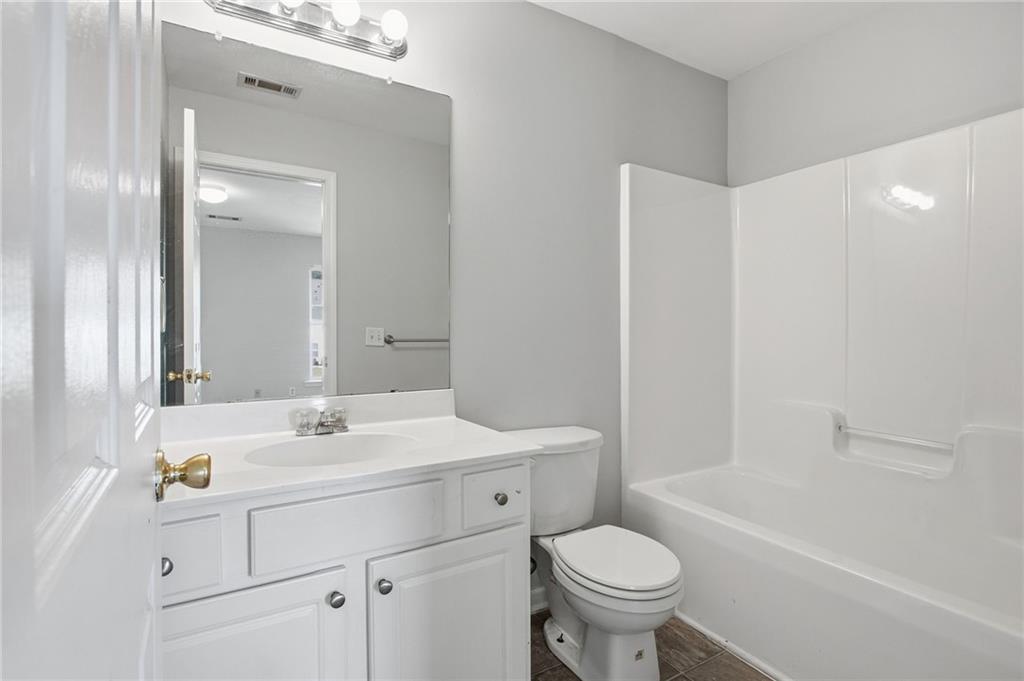 585 McWilliams Road Southeast, Unit 2402 Atlanta, GA 30315 - Photo 24 of 25 a bathroom with a sink a toilet a mirror a vanity and shower