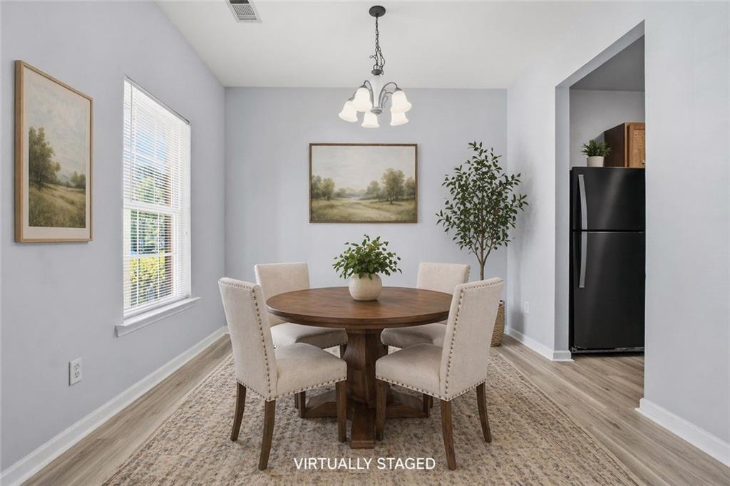 585 McWilliams Road Southeast, Unit 2402 Atlanta, GA 30315 - Photo 6 of 25 a dining room with furniture a chandelier and wooden floor