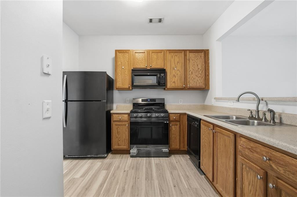 585 McWilliams Road Southeast, Unit 2402 Atlanta, GA 30315 - Photo 9 of 25 a kitchen with a refrigerator and a sink