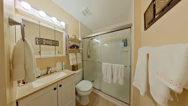 a bathroom with a granite countertop sink toilet and shower