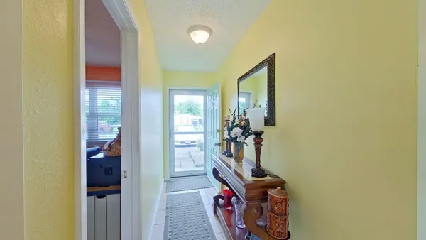 a view of a hallway with furniture and front door