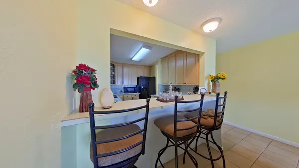 a view of a dining room with furniture and a potted plant