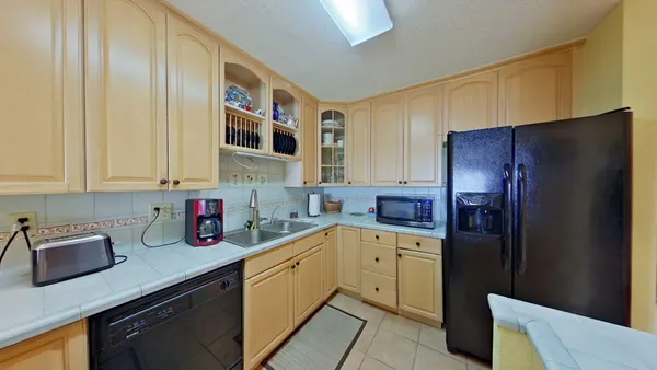 a kitchen with stainless steel appliances granite countertop a refrigerator and a sink