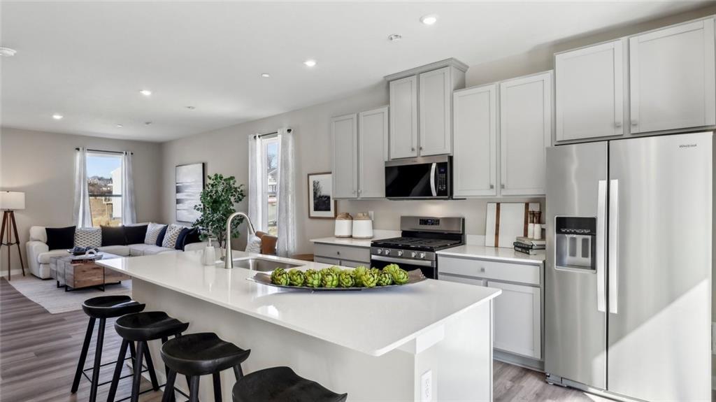 132 River Ridge Drive Coraopolis, PA 15108 - Photo 7 of 21 a kitchen with a dining table chairs refrigerator and microwave