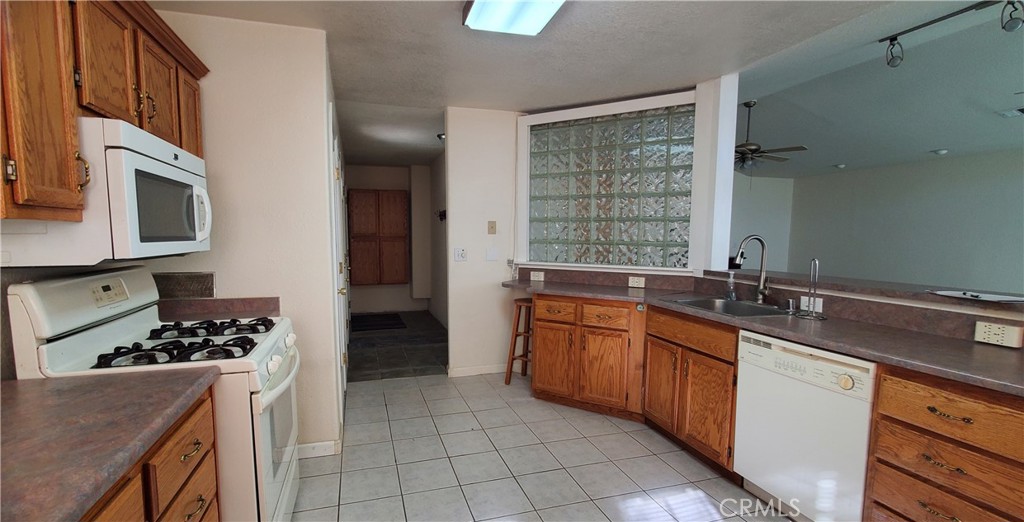 7486 Rodger Road Corning, CA 96021 - Photo 5 of 45 a kitchen with stainless steel appliances kitchen island granite countertop a sink stove and cabinets