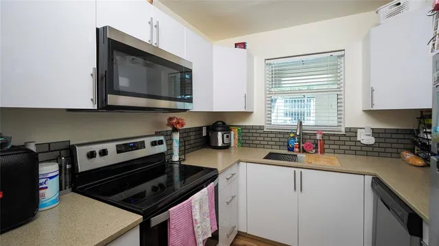 a kitchen with a stove a microwave a sink and cabinets