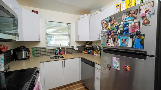 a kitchen with a refrigerator and a stove top oven