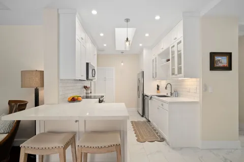 a kitchen with a table chairs sink and cabinets