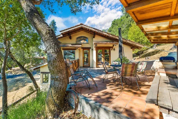 a view of a house with backyard and sitting area