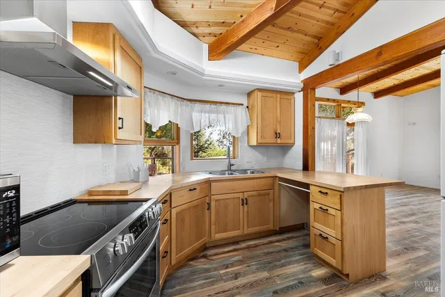 a kitchen with stainless steel appliances granite countertop a sink a stove and cabinets