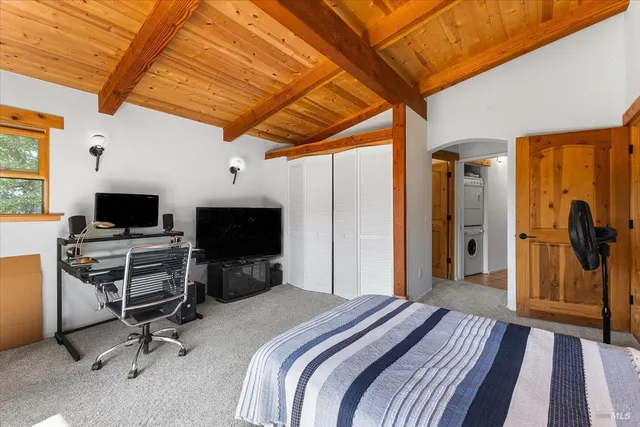 a bedroom with a bed and a flat tv screen on wall