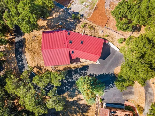 an aerial view of a house with a yard and a tree