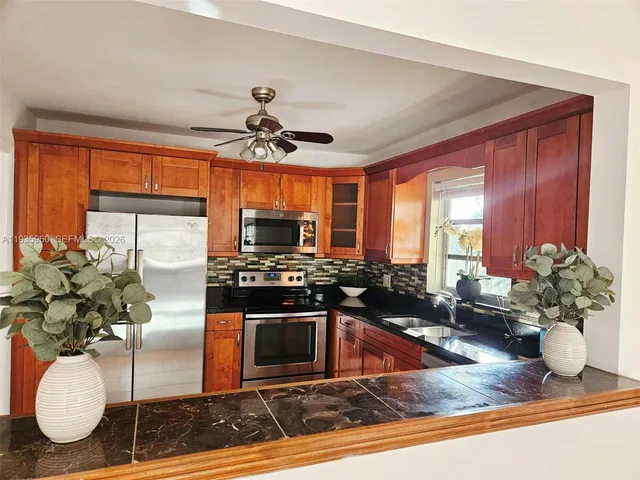 a kitchen with a stove a sink and a potted plant