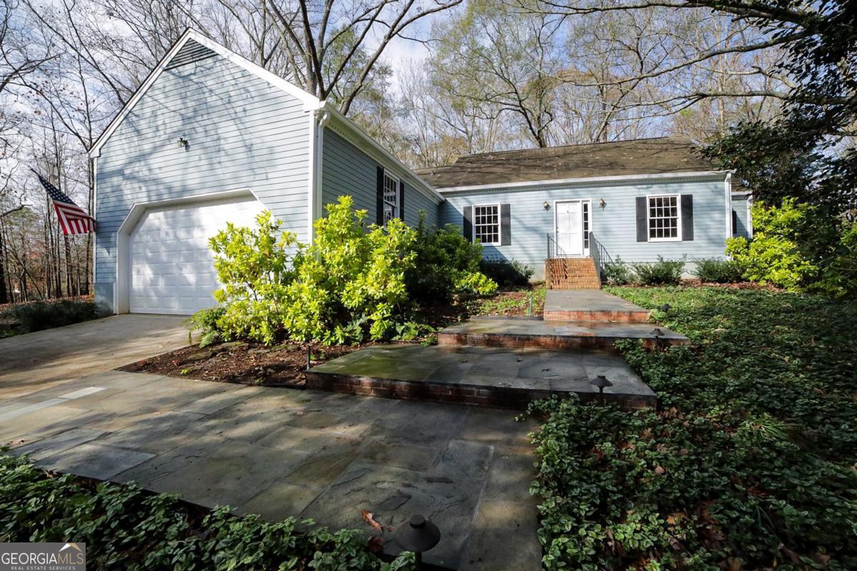 a front view of a house with a yard and a garden