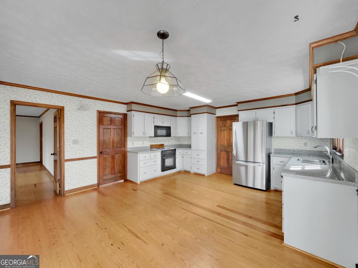 158 Lakeover Drive Athens, GA 30607 - Photo 11 of 48 a view of a kitchen with a sink and dishwasher a refrigerator with wooden floor