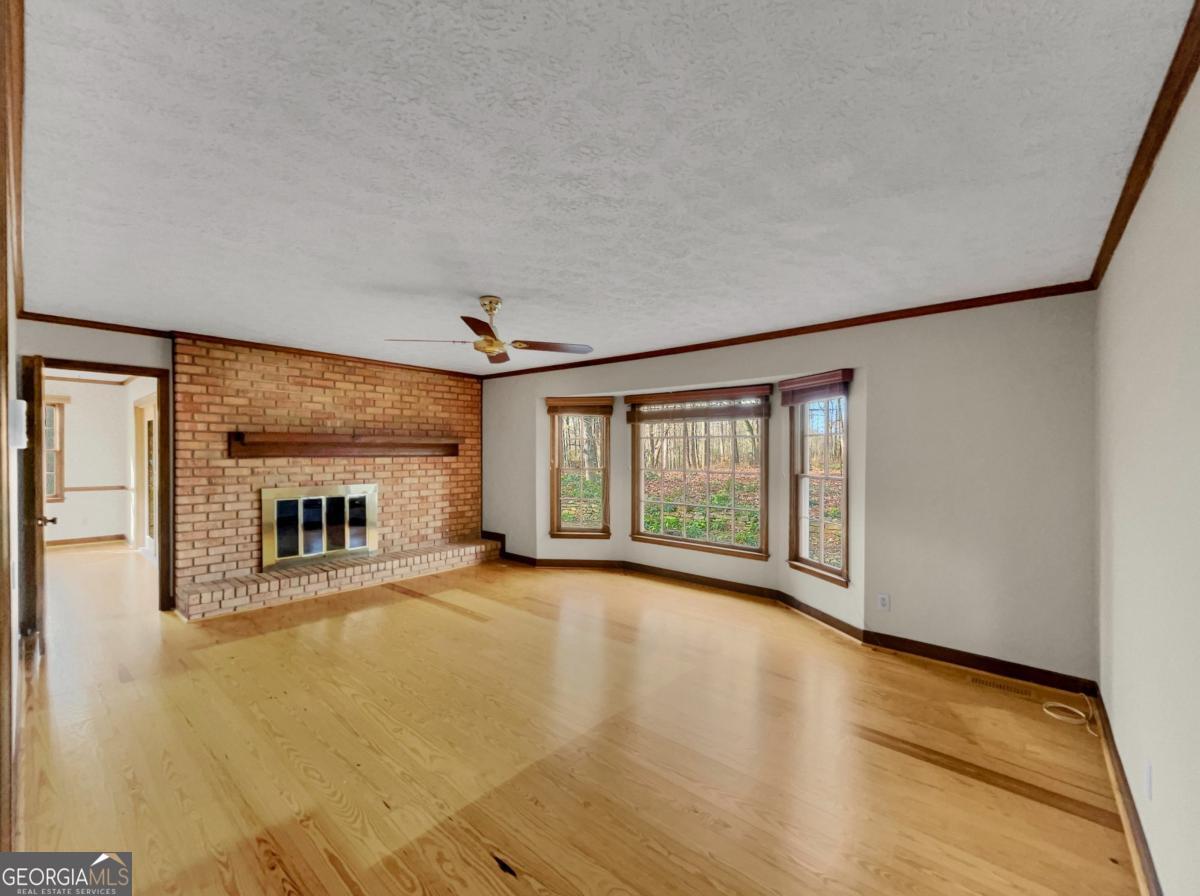 158 Lakeover Drive Athens, GA 30607 - Photo 6 of 48 a view of an empty room with a fireplace and a large window