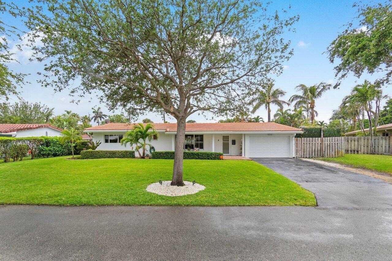 a front view of a house with a garden and yard