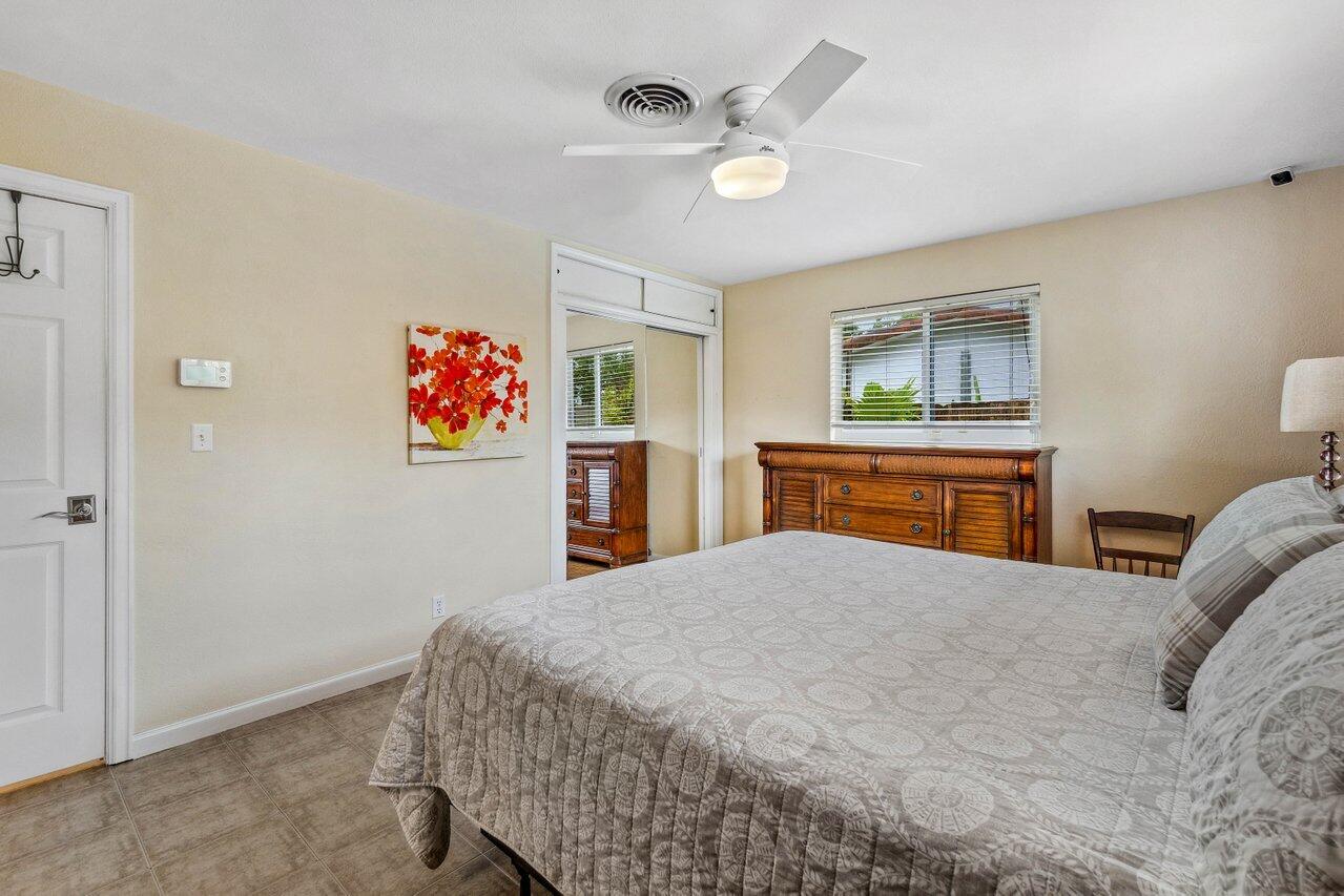 5131 Northeast 27th Terrace Lighthouse Point, FL 33064 - Photo 17 of 39 a bedroom with a bed and a chandelier