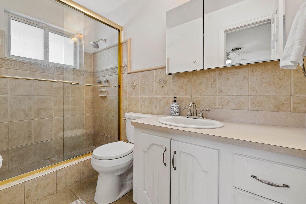 5131 Northeast 27th Terrace Lighthouse Point, FL 33064 - Photo 18 of 39 a bathroom with a sink a toilet and shower
