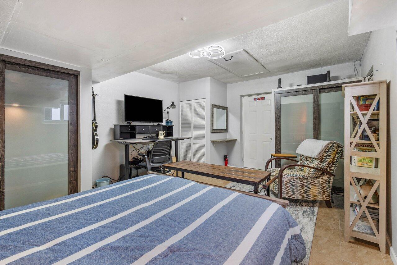 5131 Northeast 27th Terrace Lighthouse Point, FL 33064 - Photo 22 of 39 a bedroom with furniture and a flat screen tv