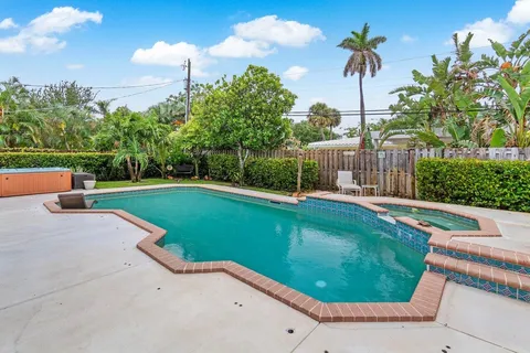 a view of a swimming pool with a garden and trees