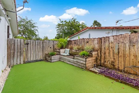 a view of a house with a yard and potted plants
