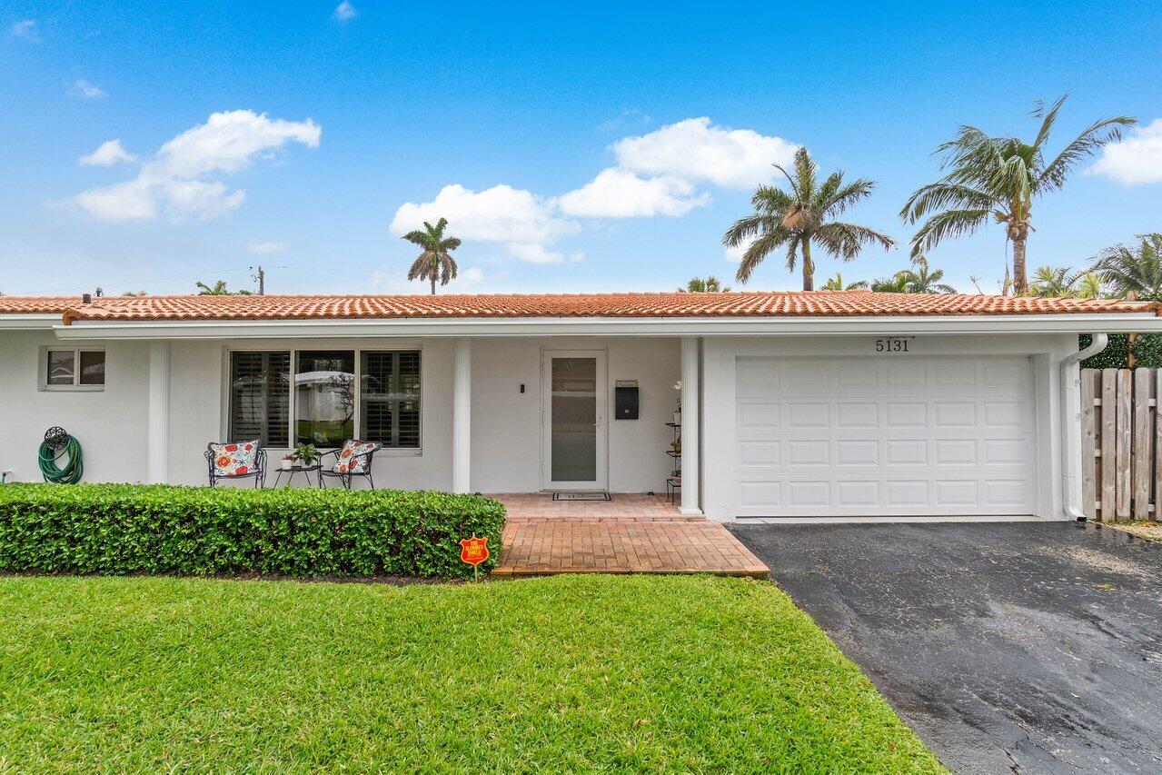 5131 Northeast 27th Terrace Lighthouse Point, FL 33064 - Photo 34 of 39 a view of a house with a yard and potted plants
