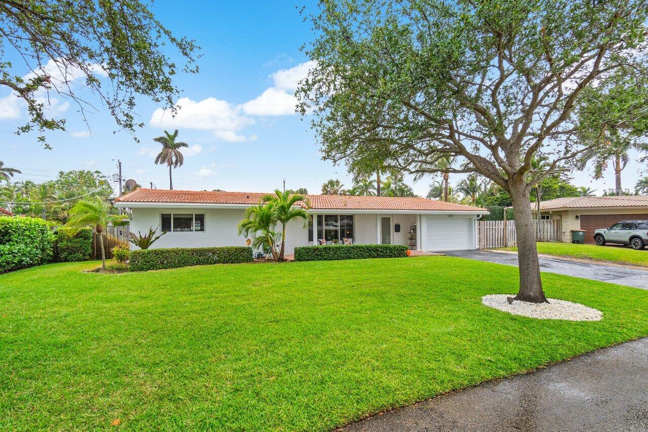 5131 Northeast 27th Terrace Lighthouse Point, FL 33064 - Photo 35 of 39 a front view of a house with a garden