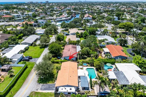 an aerial view of residential houses with outdoor space and trees all around