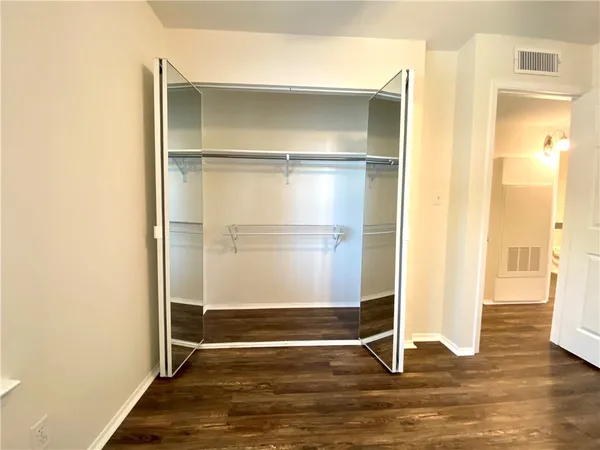 a view of walk in closet with empty racks