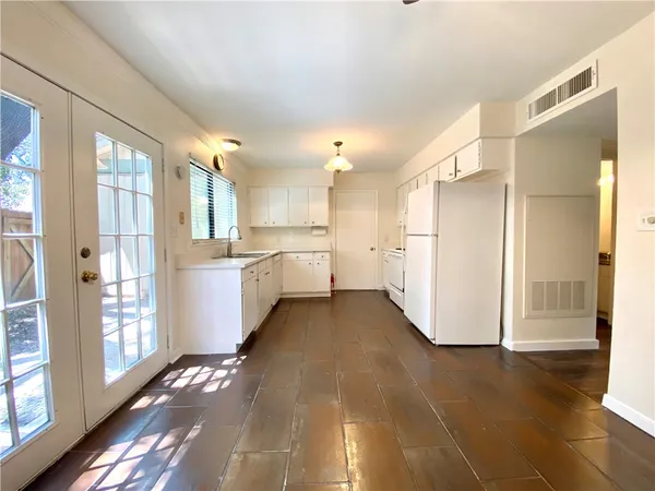 a view of a kitchen with a refrigerator and wooden floor