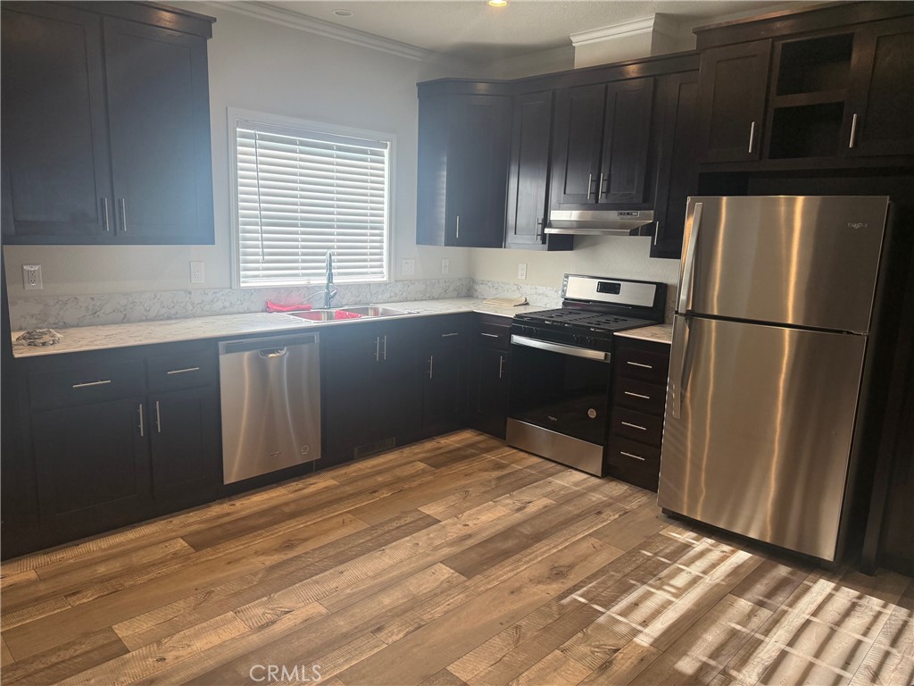 14450 Meridian Road Chico, CA 95973 - Photo 5 of 37 a kitchen with granite countertop wooden cabinets a refrigerator and a sink
