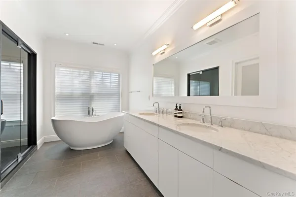 a bathroom with a granite countertop sink mirror and bathtub
