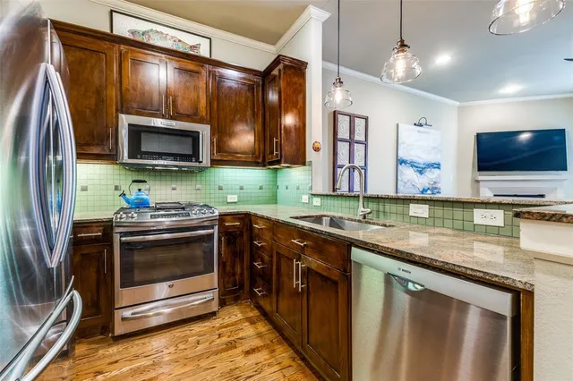 a kitchen with stainless steel appliances granite countertop a sink microwave and stove top oven